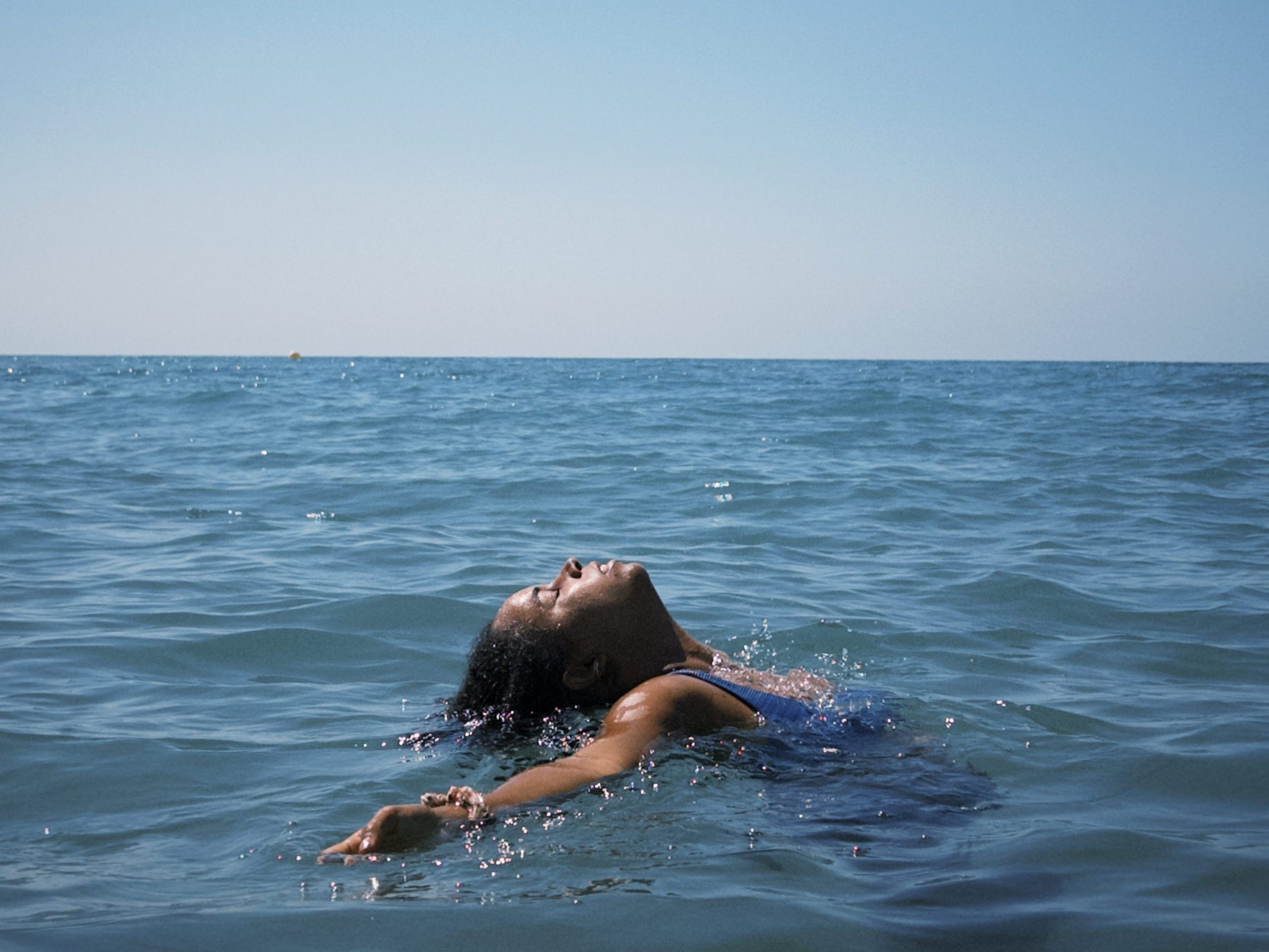 chica en la playa dentro del agua relajada